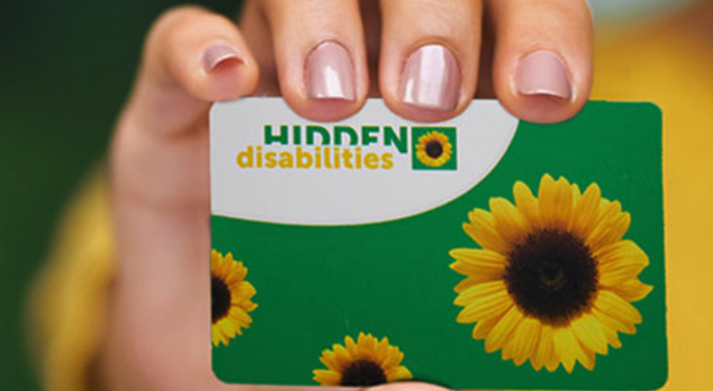 Image of card with text Hidden disabilities and sunflowers on a green backgroun.