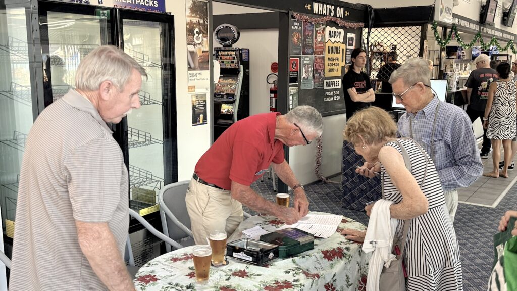 Members and guests of the Hunter Valley Branch of the Laryngectomee Association check-in at front desk for the annual Christmas party. 