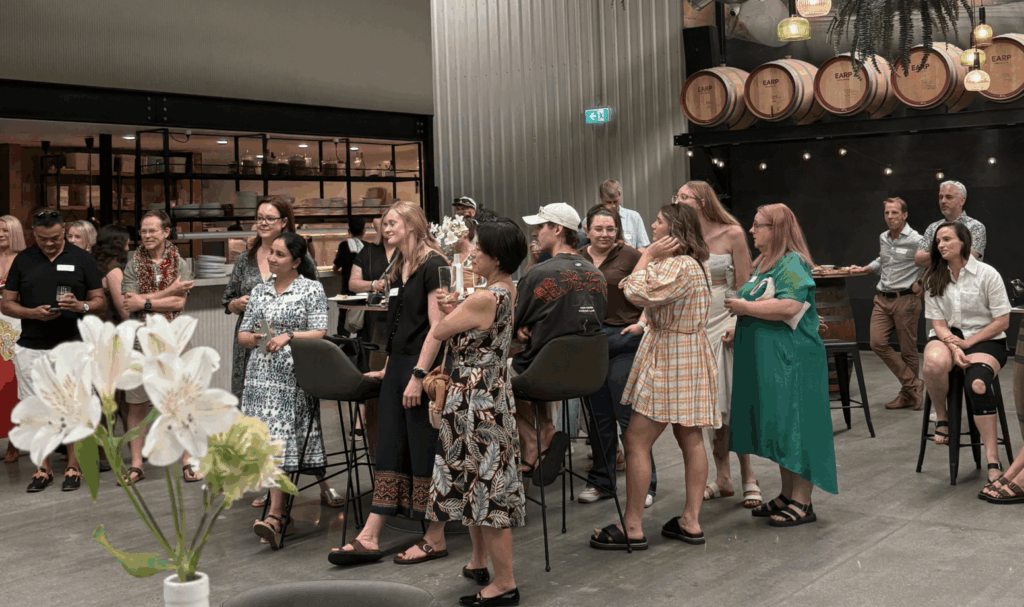A group of men and women watching a performance of a laryngectomee choir